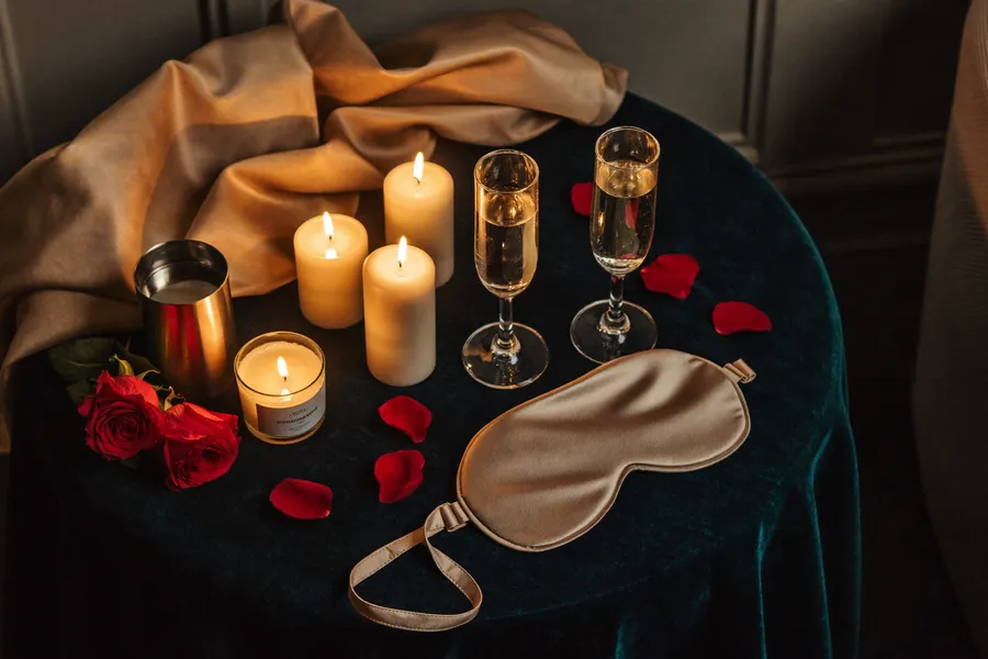 Romantik-Set mit Kerzen, Rosenblättern und Champagner