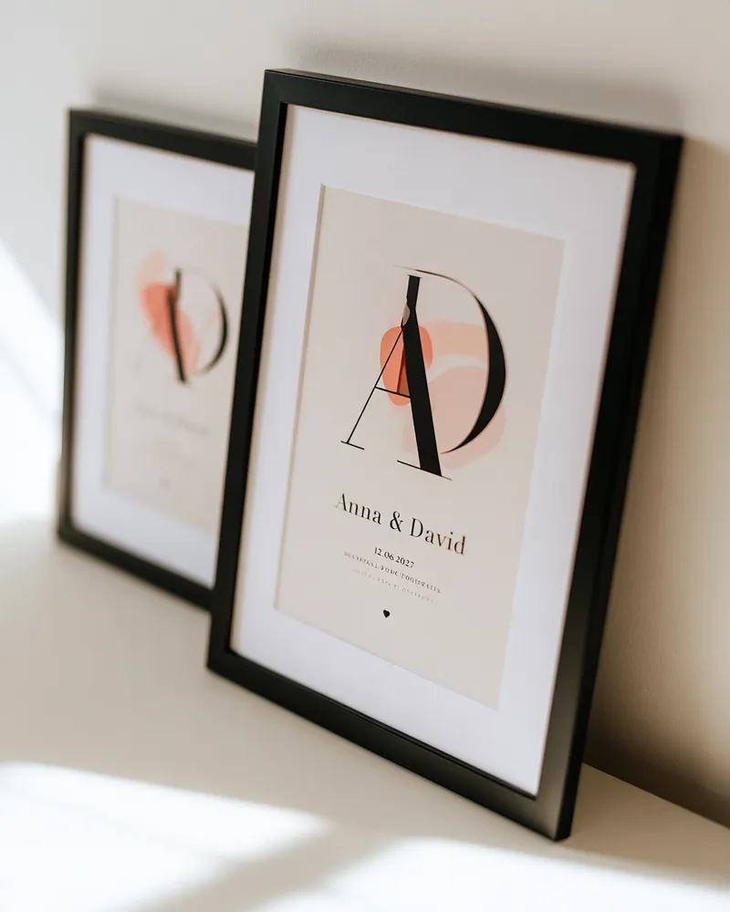 Zwei schwarz gerahmte Monogramm-Poster mit verschlungenen Initialen A und D, Namen und Datum – Geschenk zur Verlobung oder Hochzeit